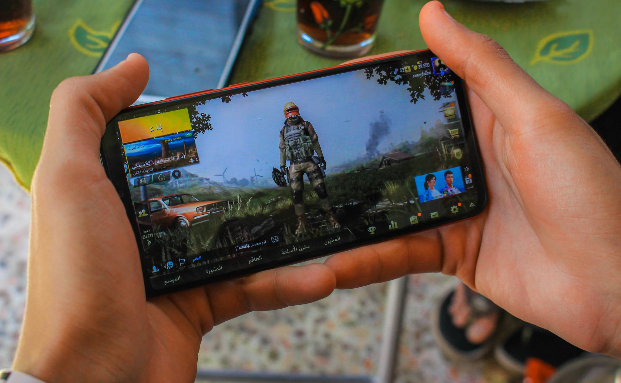 Close-up of a man playing a video game on a smartphone outdoors in Syria.